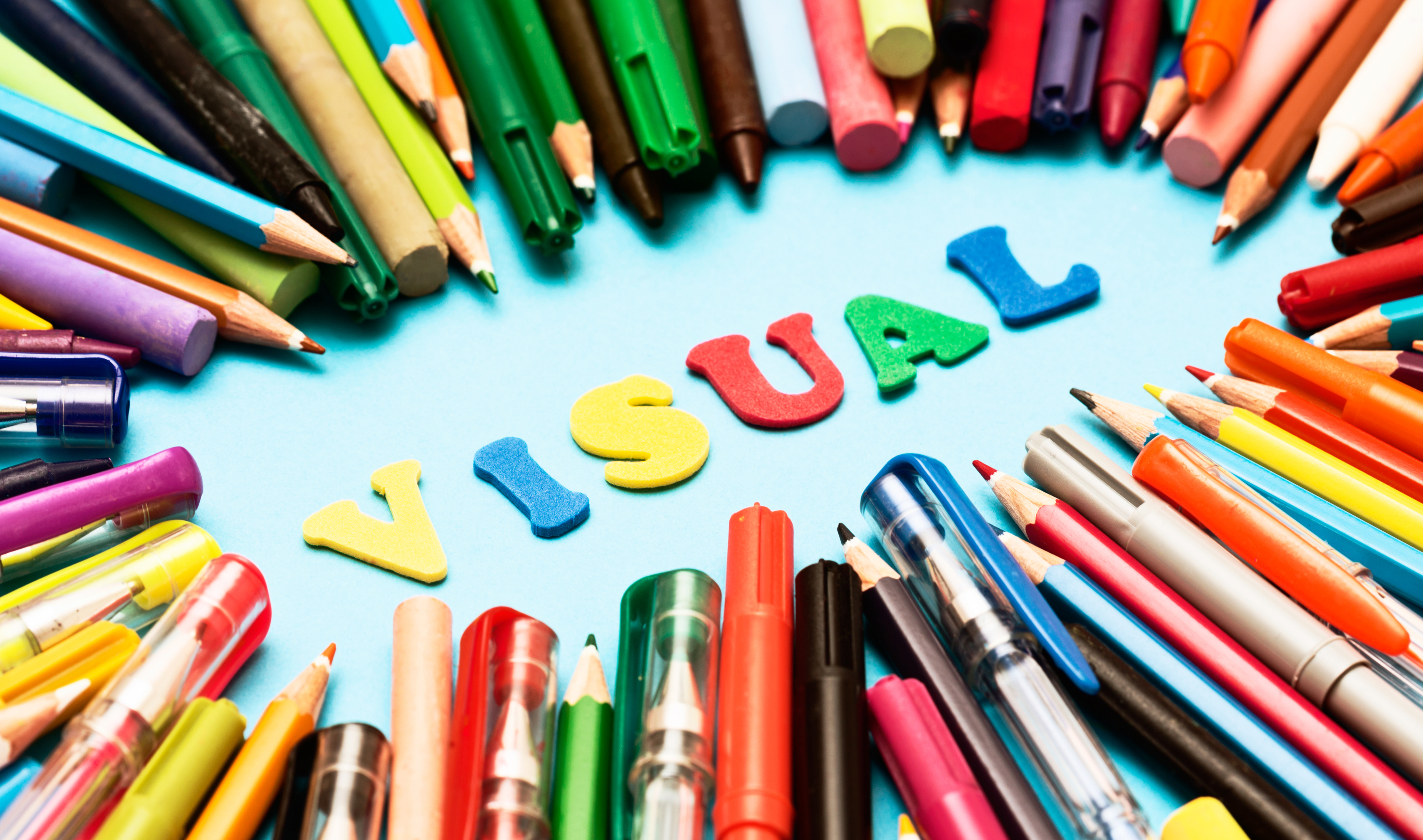 VISUAL say play letters surrounded by drawing materials